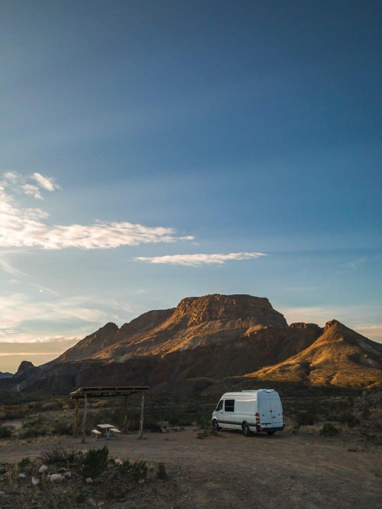 The white Sprinter camps out in Big Bend State Park. There is a large butte off in the distance.