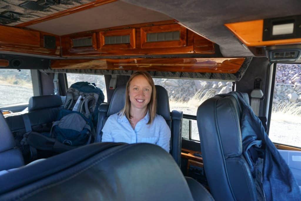 Girl sits inside of her conversion van.