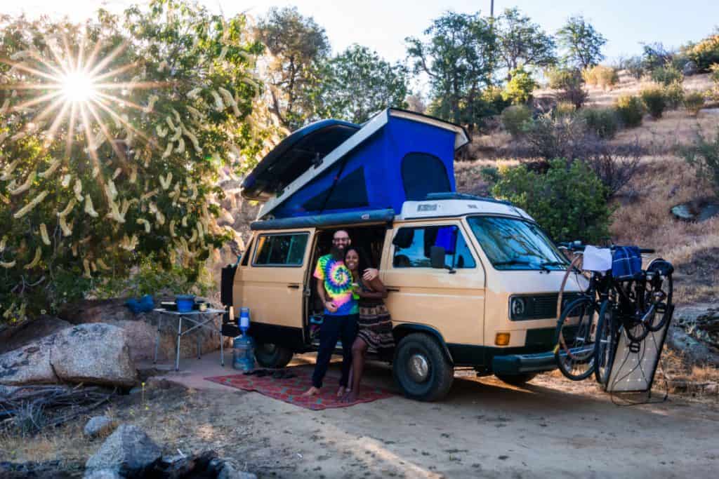 Man and woman hug happily outside their van