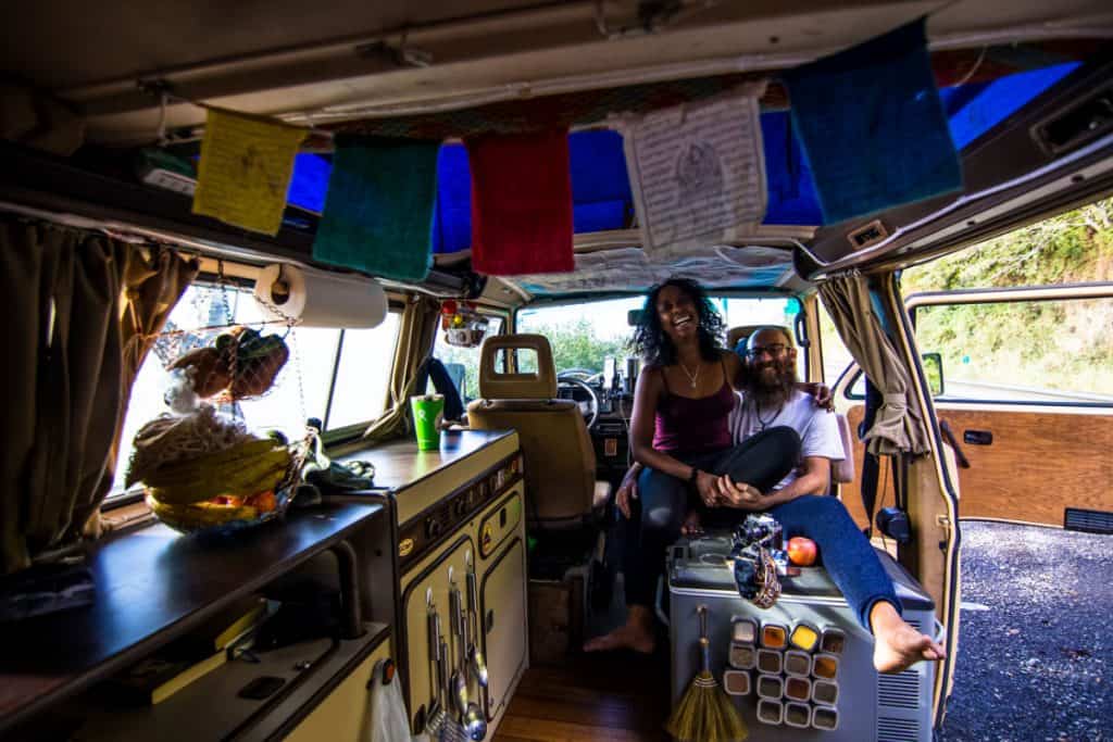 man and wife happily sit with each other inside their van