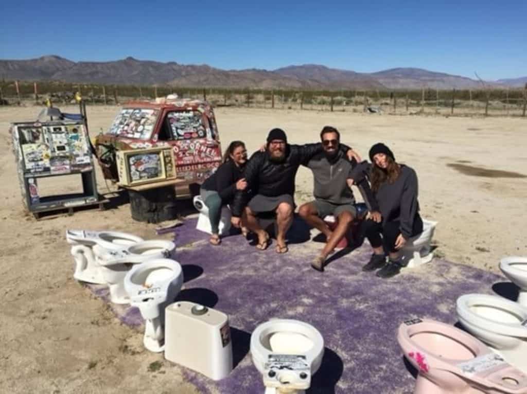 Meghan and Stephen sit with two friends on old toilets turned into seats.