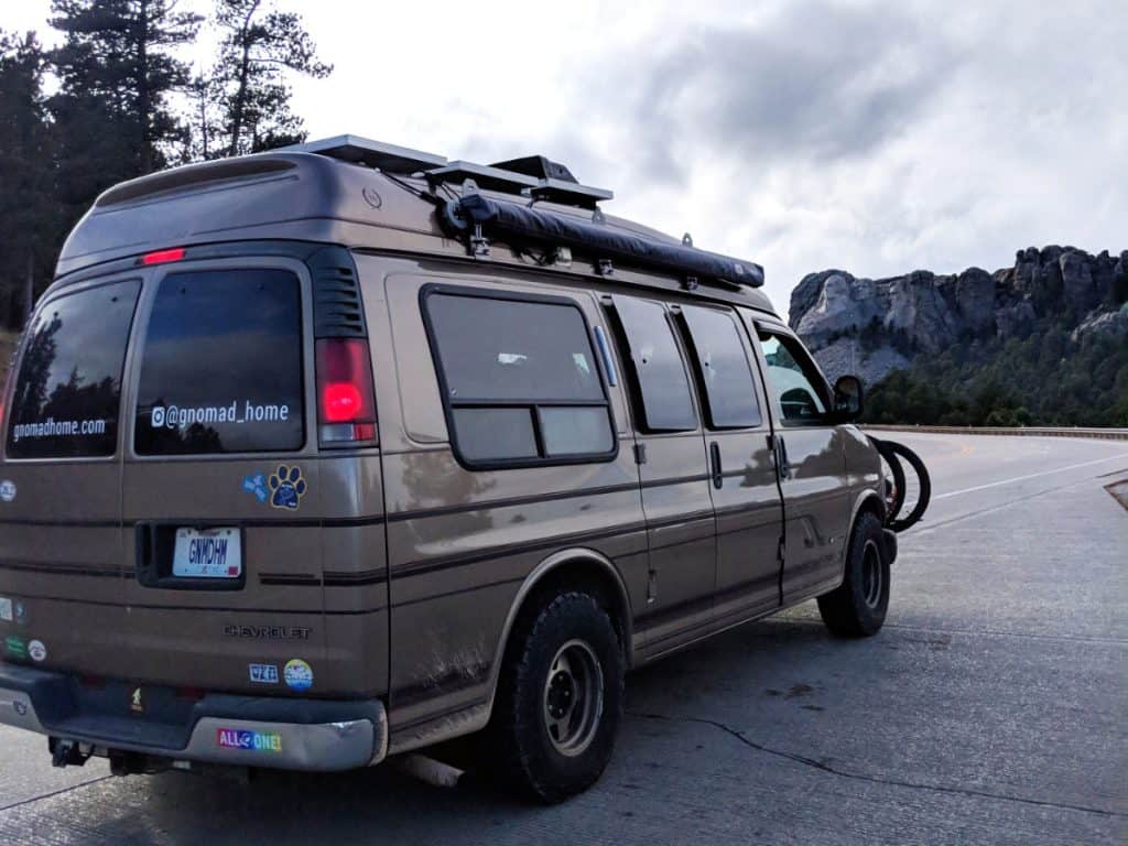 A van is stopped on the road looking at the famed Six Grandfathers mountain