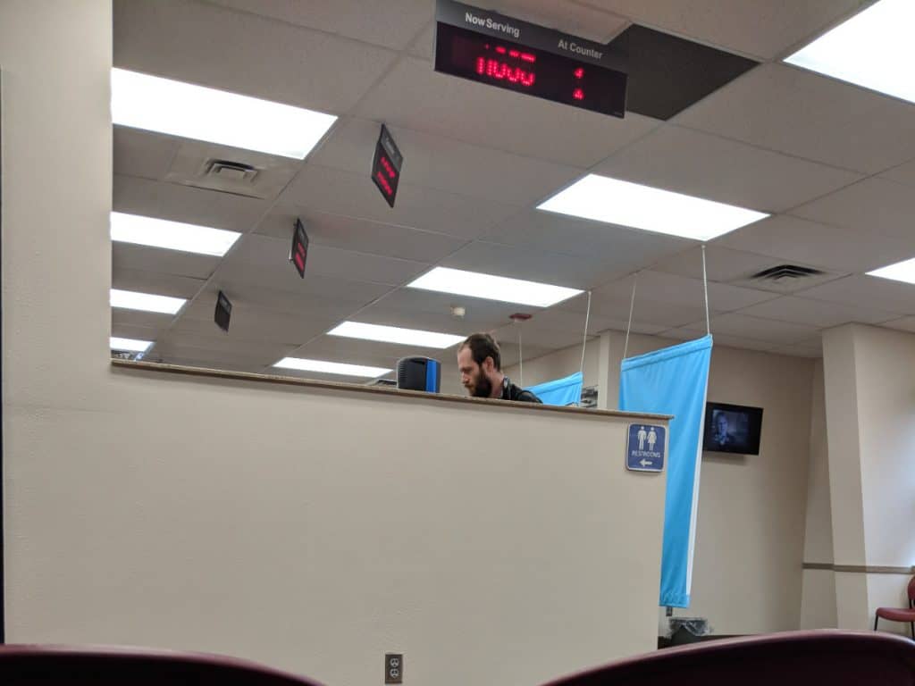 Man stands at the counter at a DMV office