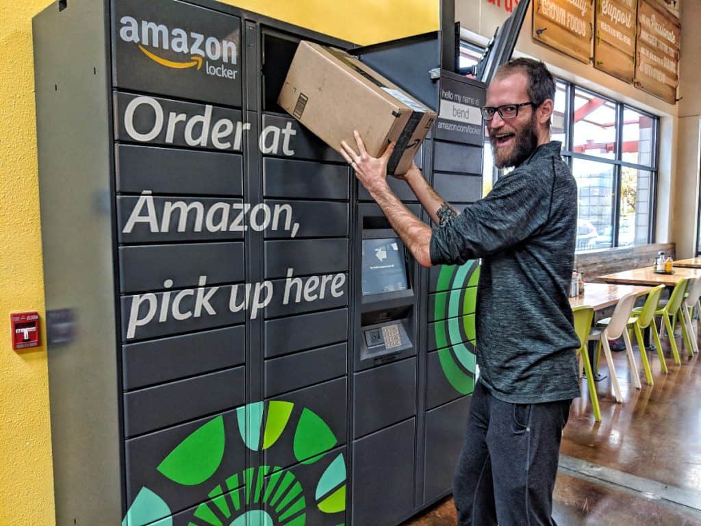 man happily removes a package from an amazon locker