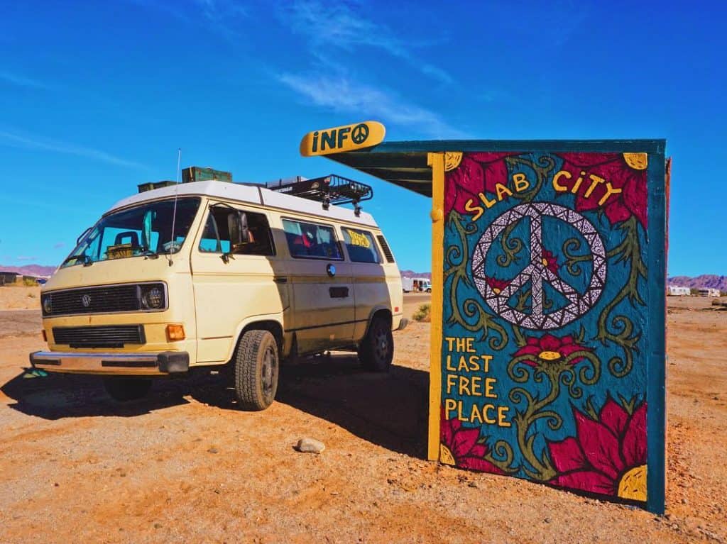 VW Van parked near slab city welcome sign