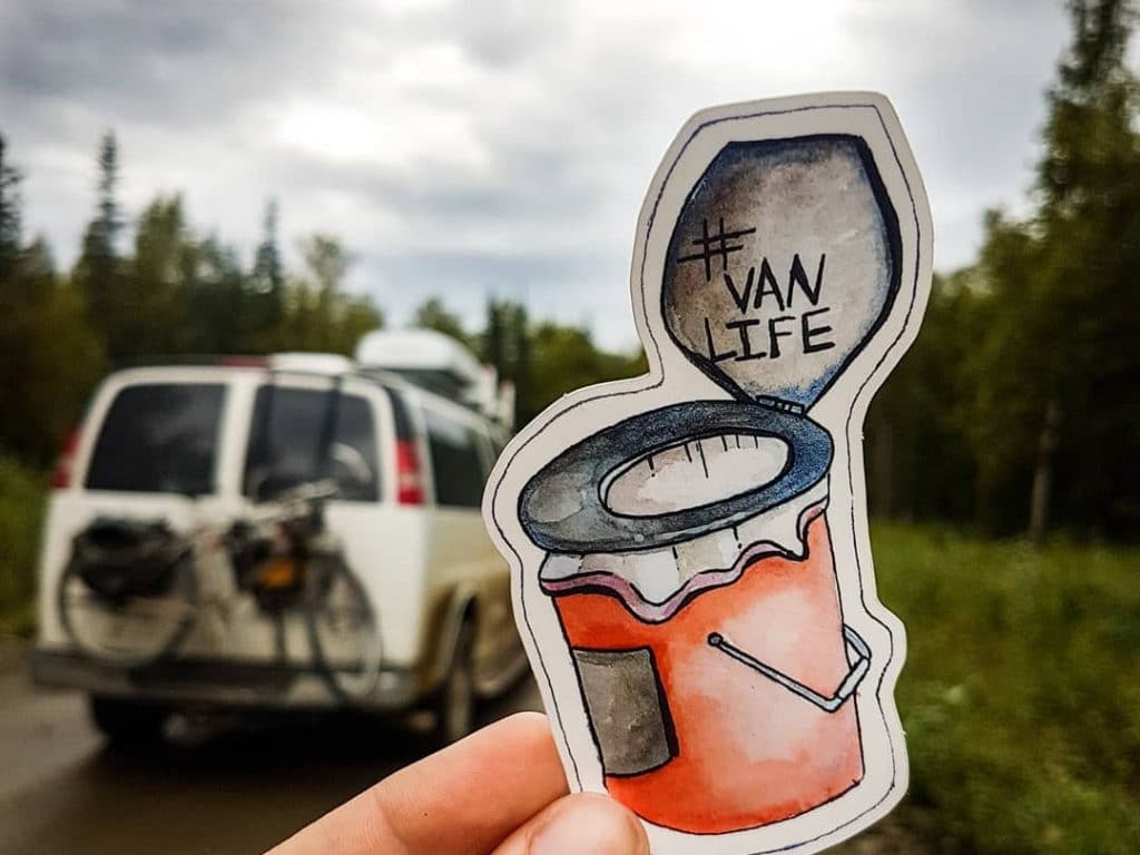 Sticker showing a bucket with a toilet seat on top that says #vanlife, with van in background