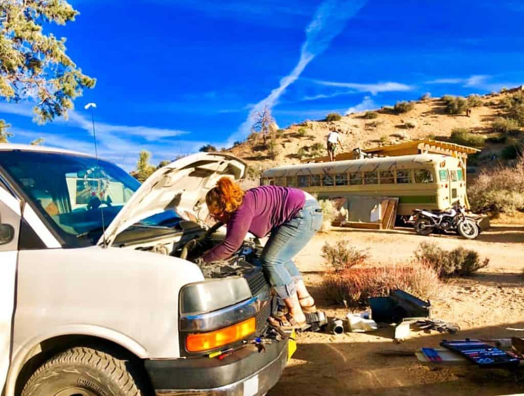 Woman fixing her van's engine