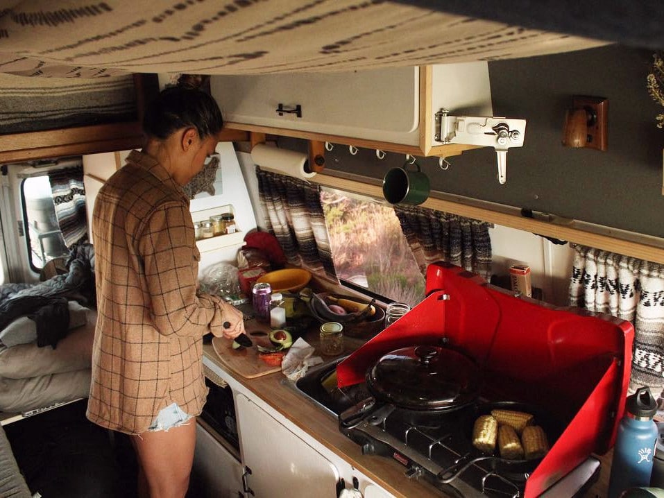 Woman cooking inside campervan