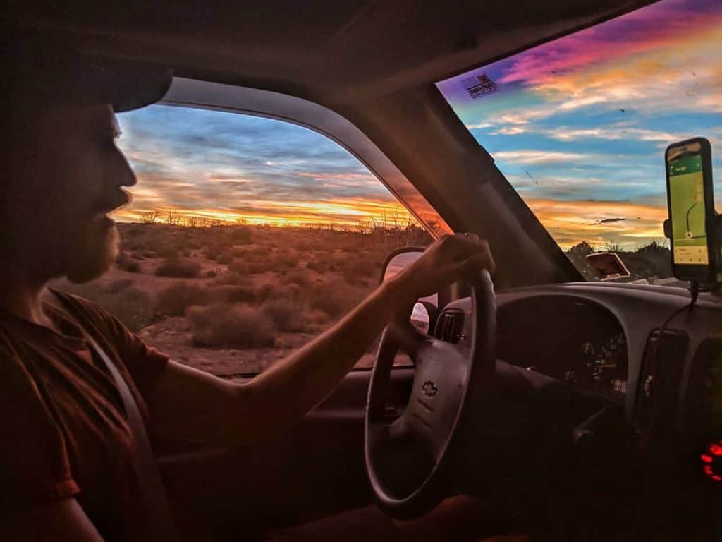 Man driving van into sunset