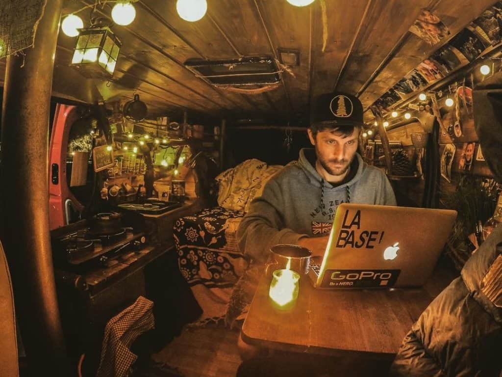 man sits in front of computer working inside his van