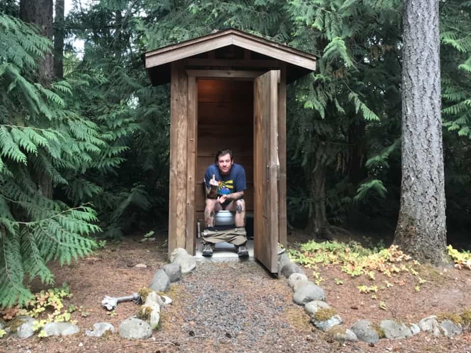 man using an outhouse