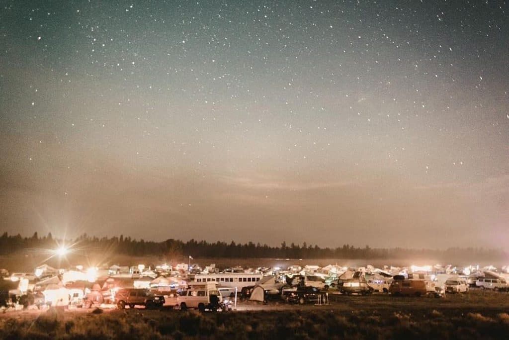 nighttime photo of a bunch of vehicles camped out under the stars