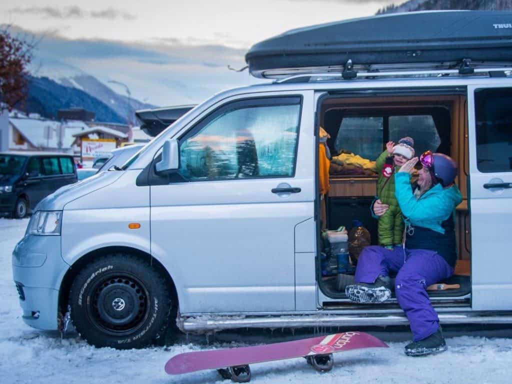 woman and child high five in van - van surrounded by snow