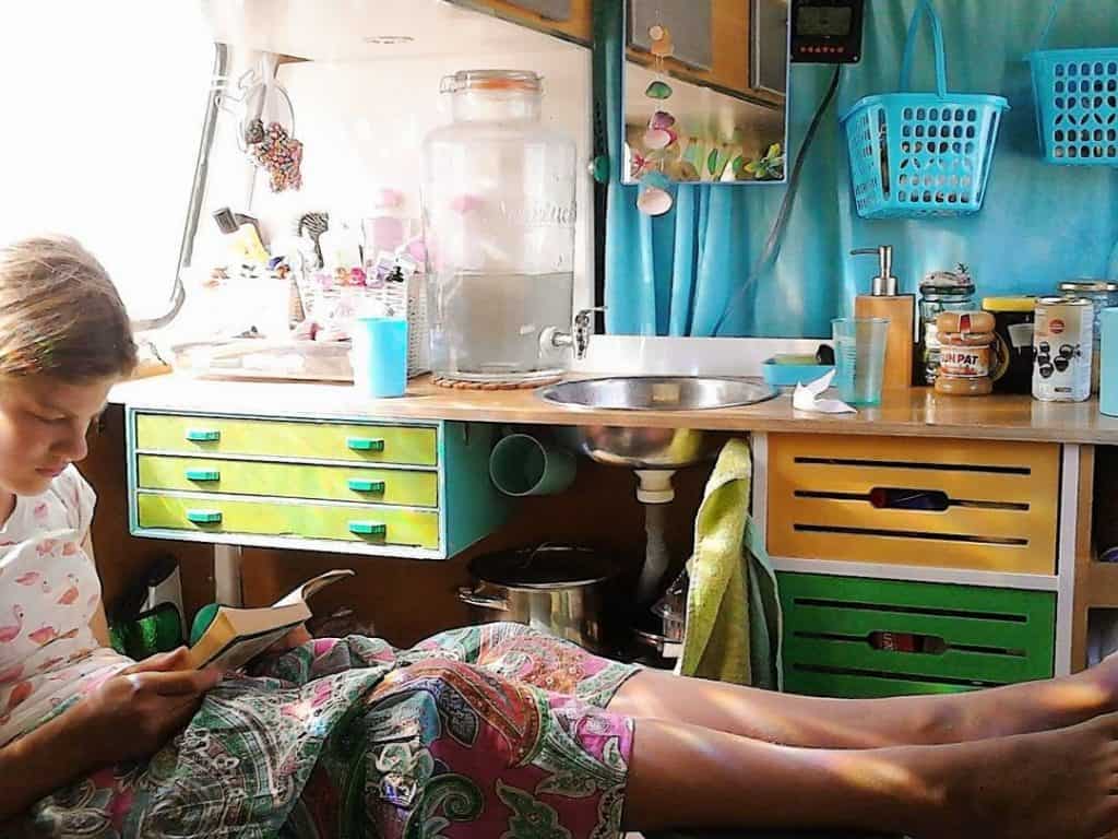 woman reads in van next to her kitchen