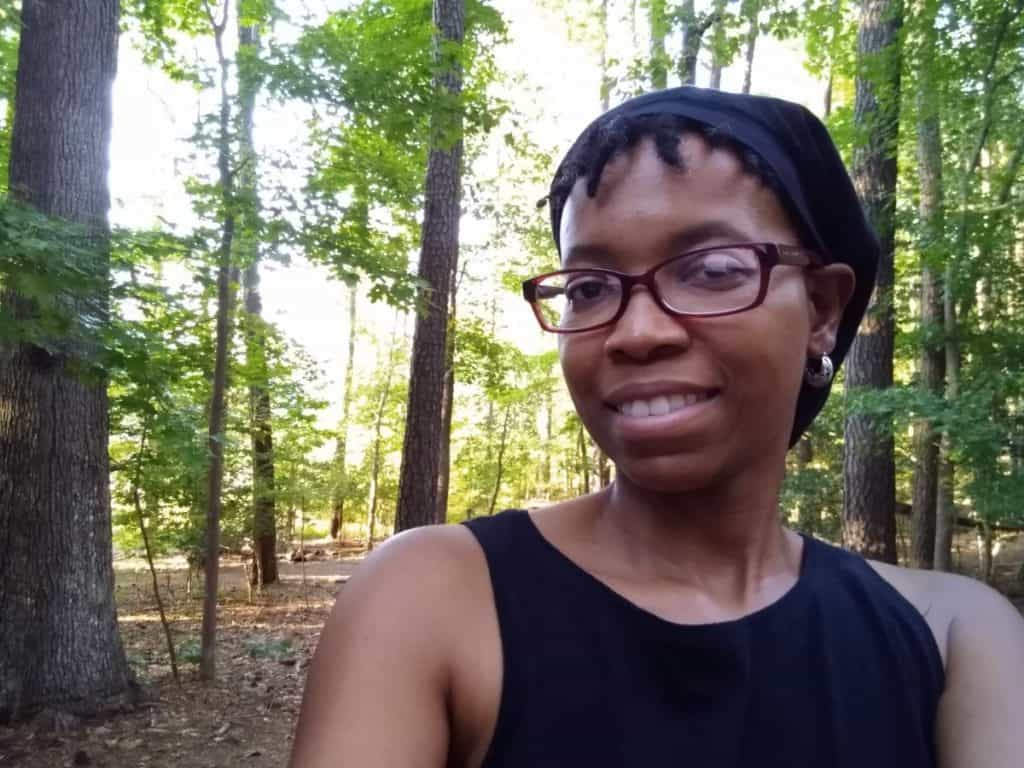 Crystal smiles with trees behind her