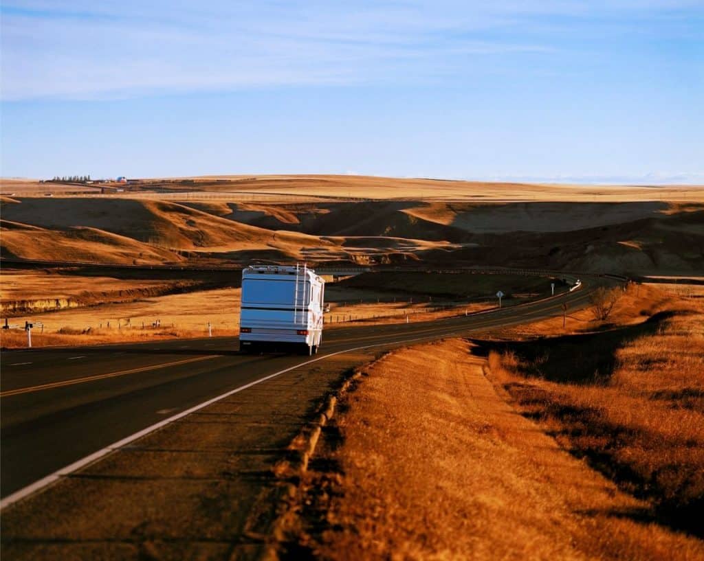 class a rv driving down a desert highway