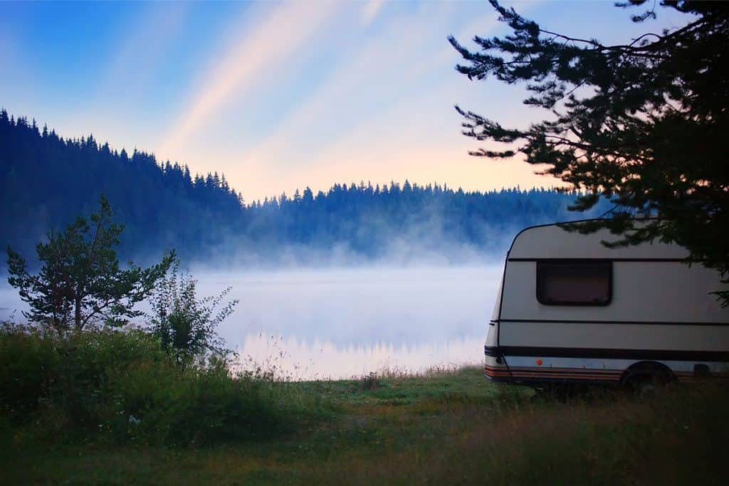 trailer rv parked by a misty alpine lake