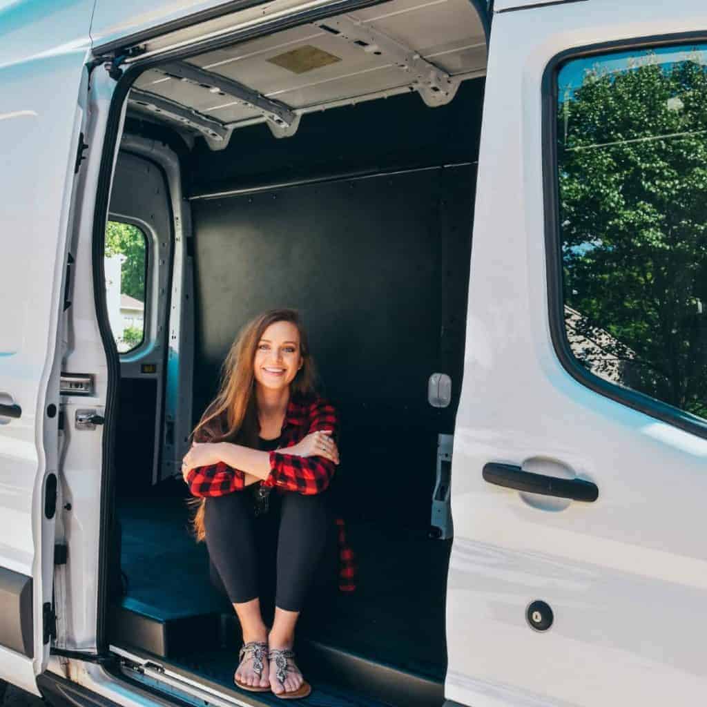 Sydney sits out the side door. Walls seem to be up in the van and a floor looks like it's installed too.