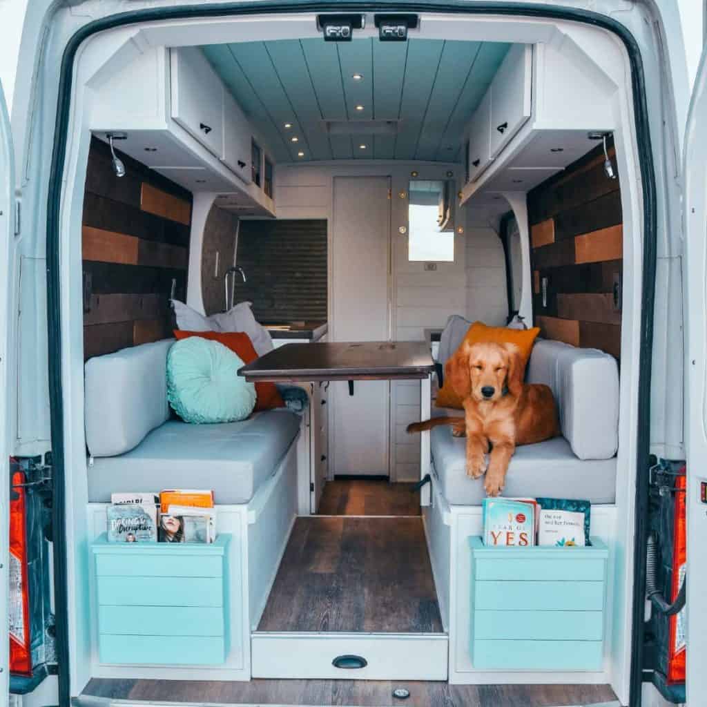 Ella sitting on the couch looking relaxed, the inside of the van is fully built out.