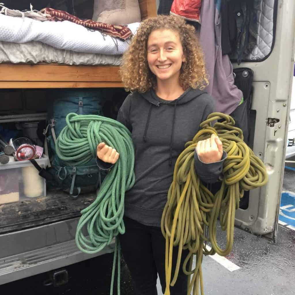 Kaya holds two bundles of ropes out the back of her van.