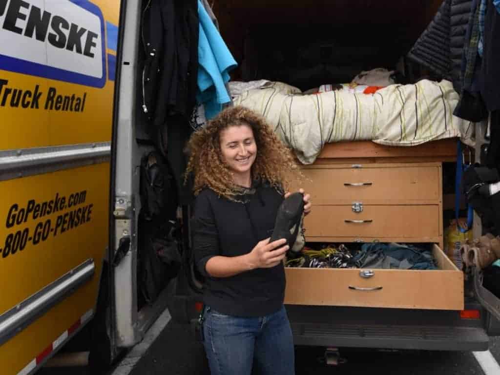 Kaya holds a shoe out the back of her van.