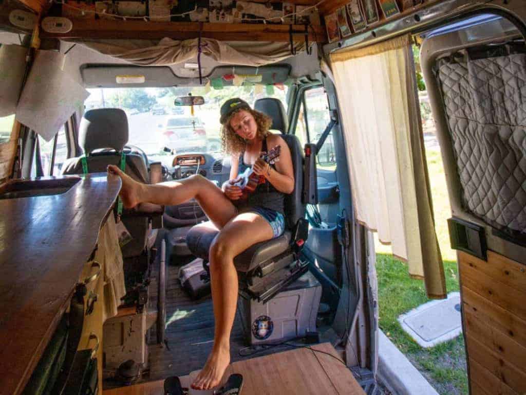 Kaya sits on swivel seat playing the ukulele.