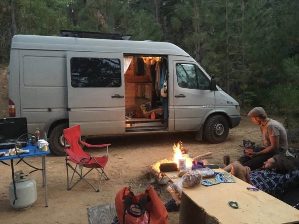 They have a campfire outside of the van.