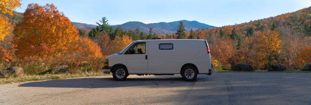 Chris' van surrounded by trees changing their leaves with autumn.