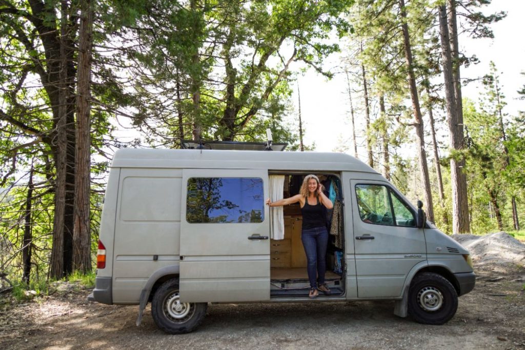 Kaya standing on the side door of her sprinter van