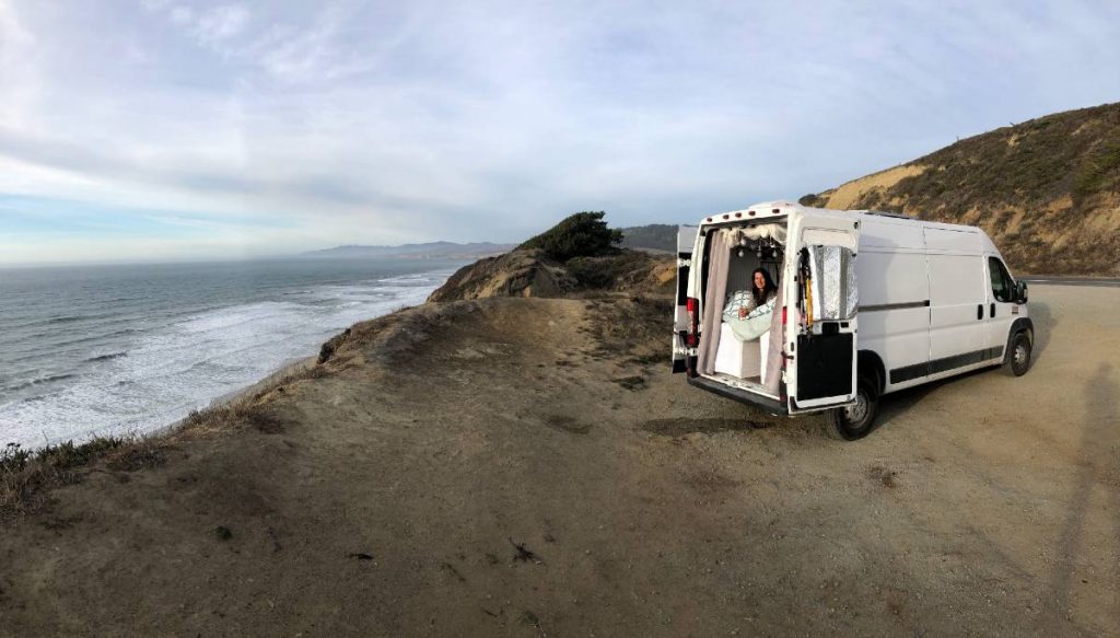 Dodge promaster parked at the beach with the back doors open