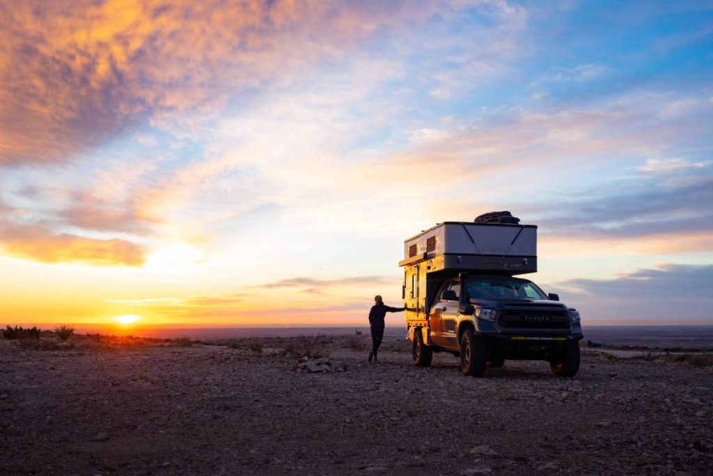 Camião Toyota com caravana estacionada por um pôr-do-sol incrível