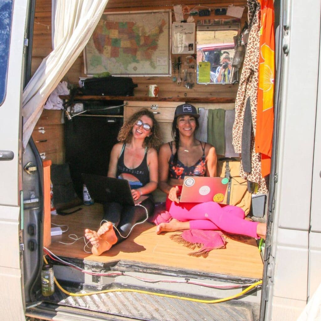 Two women hanging out in a Sprinter on their computers