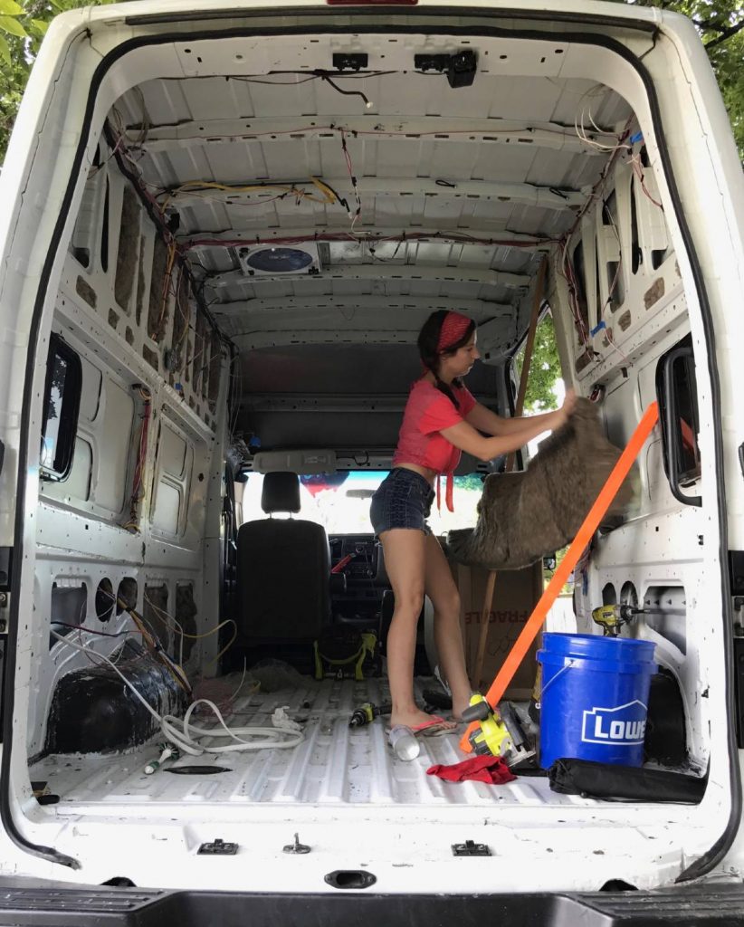 Lisa Jacobs gutting and cleaning the interior of her van