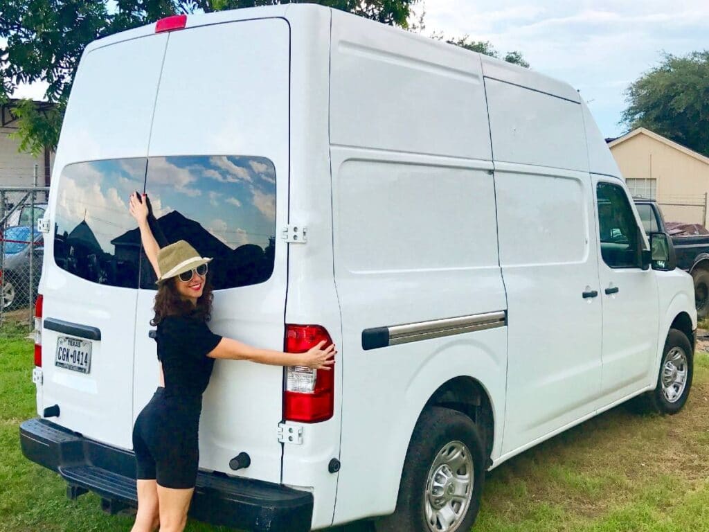 Woman hugging her Nissan NV2500 van