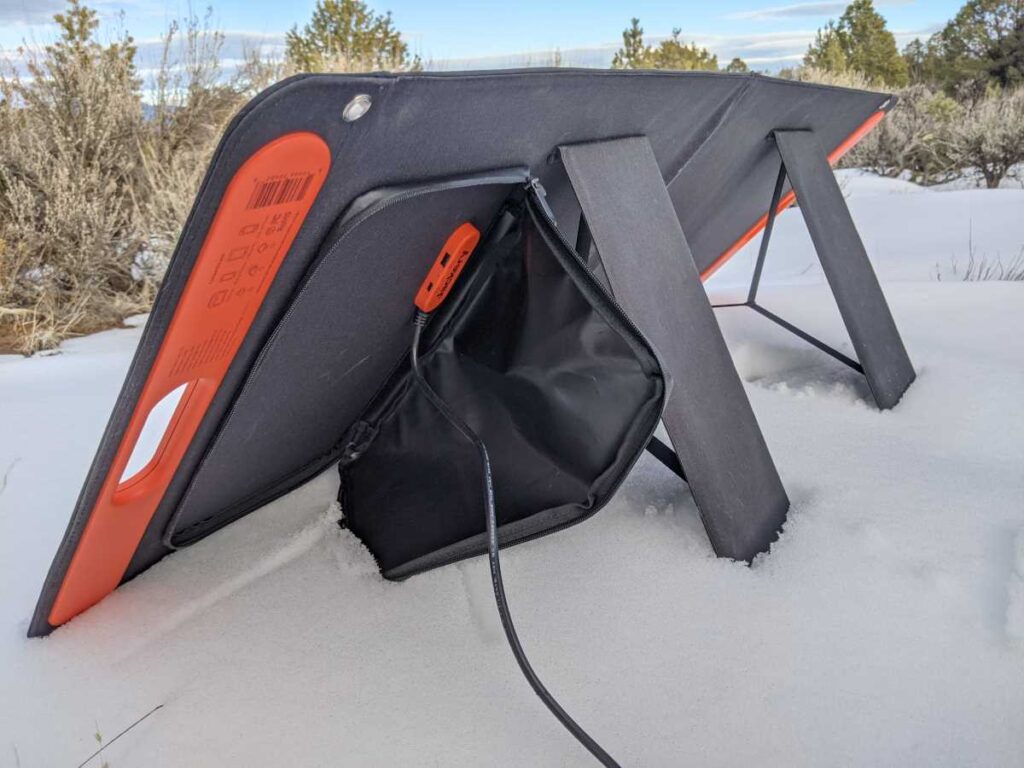 The SolarSaga 100W solar panel from behind, showing the kickstand, the cable pouch, and the USB ports