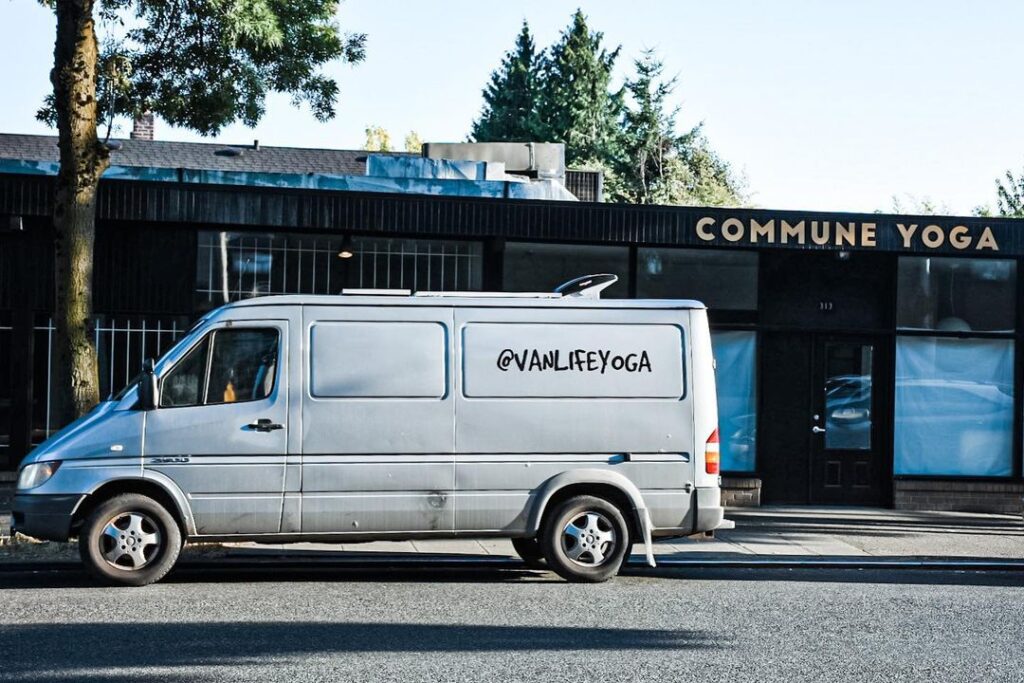 Sprinter van with #vanlifeyoga spray painted on the side