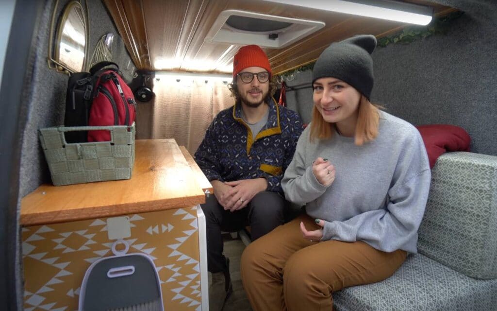 @mikeandheathervlog Man and woman sitting inside a ford transit connect camper van