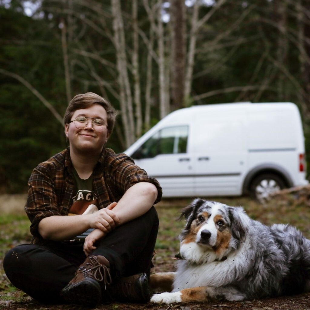@milomeloy Man with his dog sitting near ford transit connect campervan
