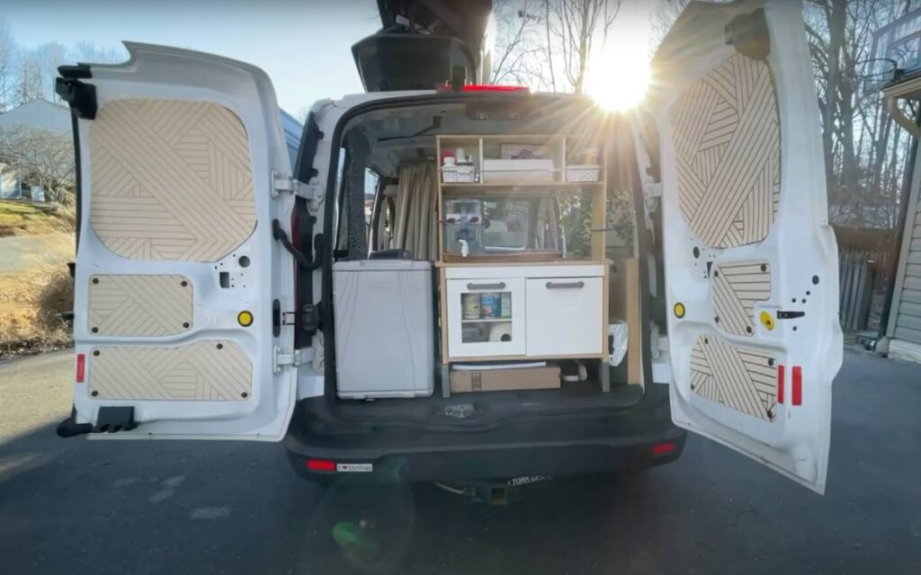 @nomadshewrote Open rear door of a transit connect campervan with fridge