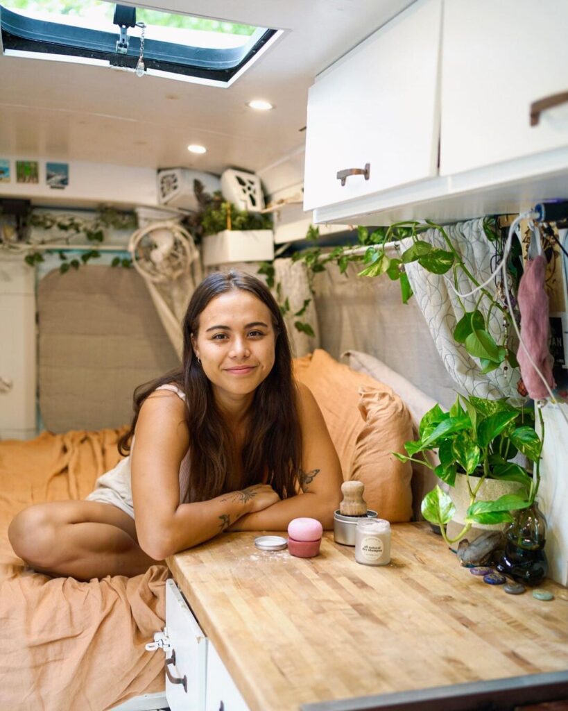 @sarahyak_ woman sitting on bed in a ford camper van