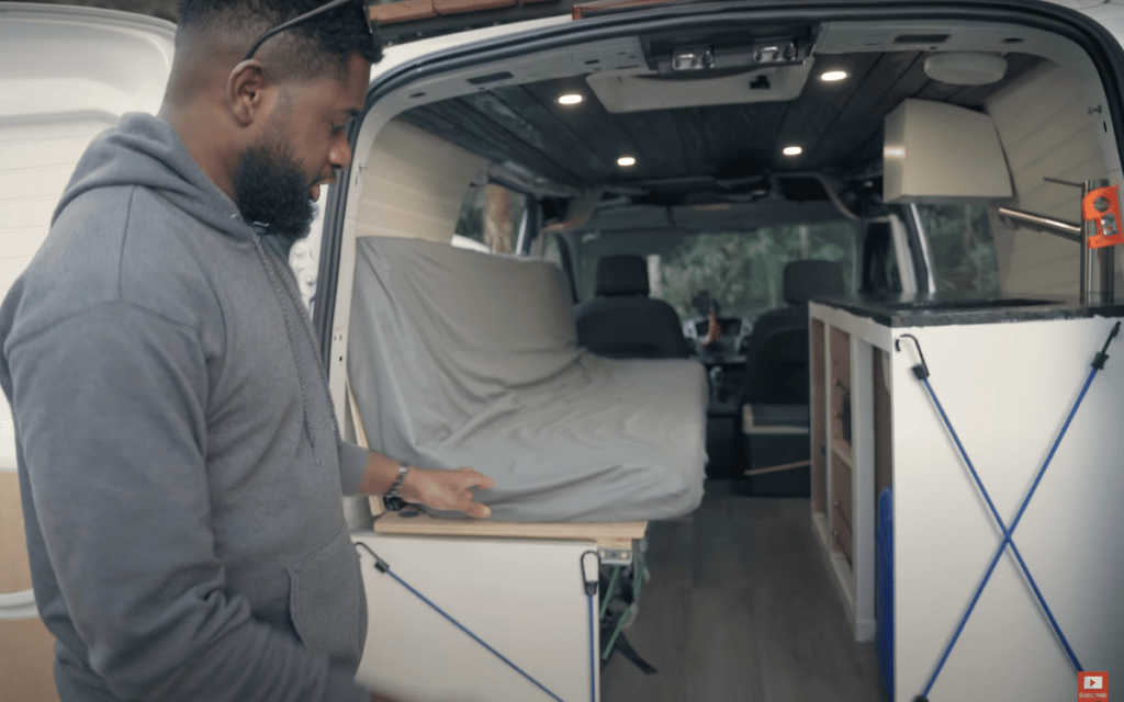 alain maven showing off the inside of his ford transit connect camper van conversion