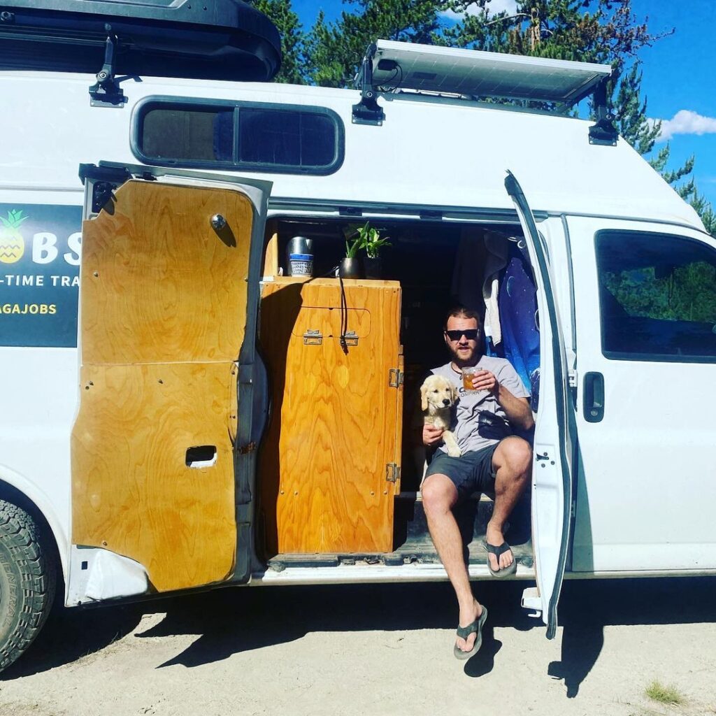 @dylventures Man and his dog sitting on chevy express camper van doorway