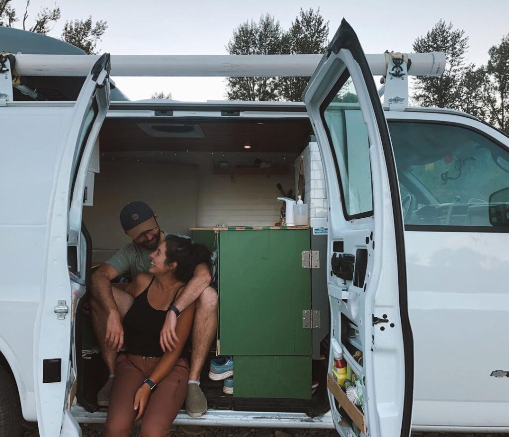@emily_mcdo Couple sitting on chevy express camper van doorway