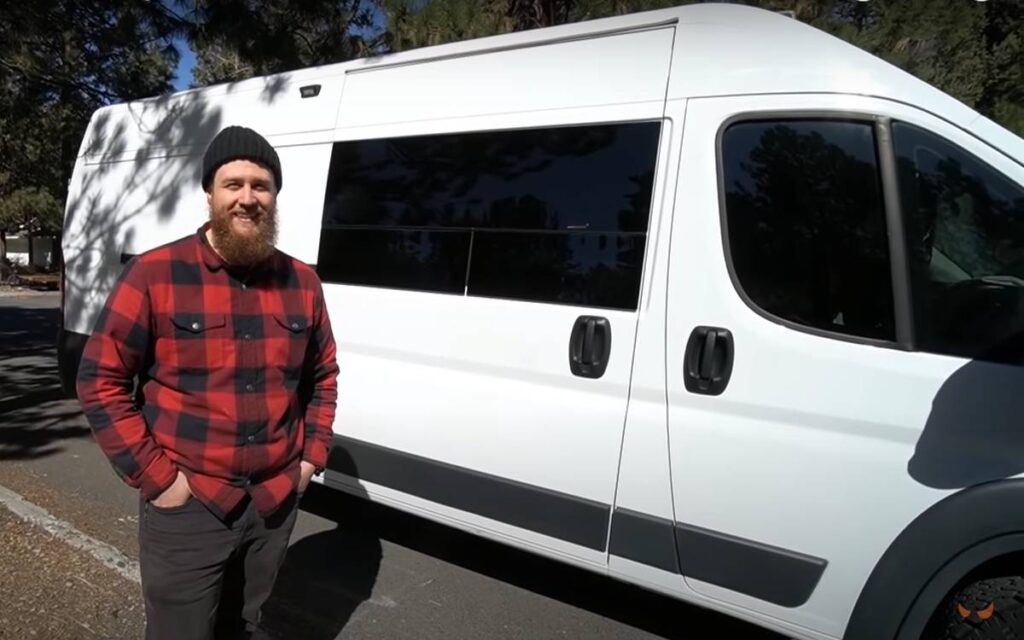 @whereskevinroemer Man standing beside his ram promaster camper van