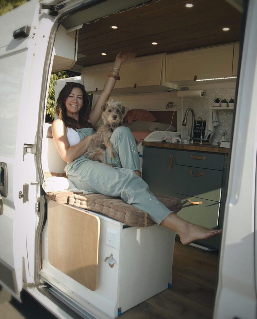 @carrielynnconrad Woman with her dog inside ram promaster camper van