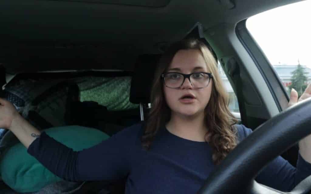 Kiersten sitting in the driver's seat of her camper car