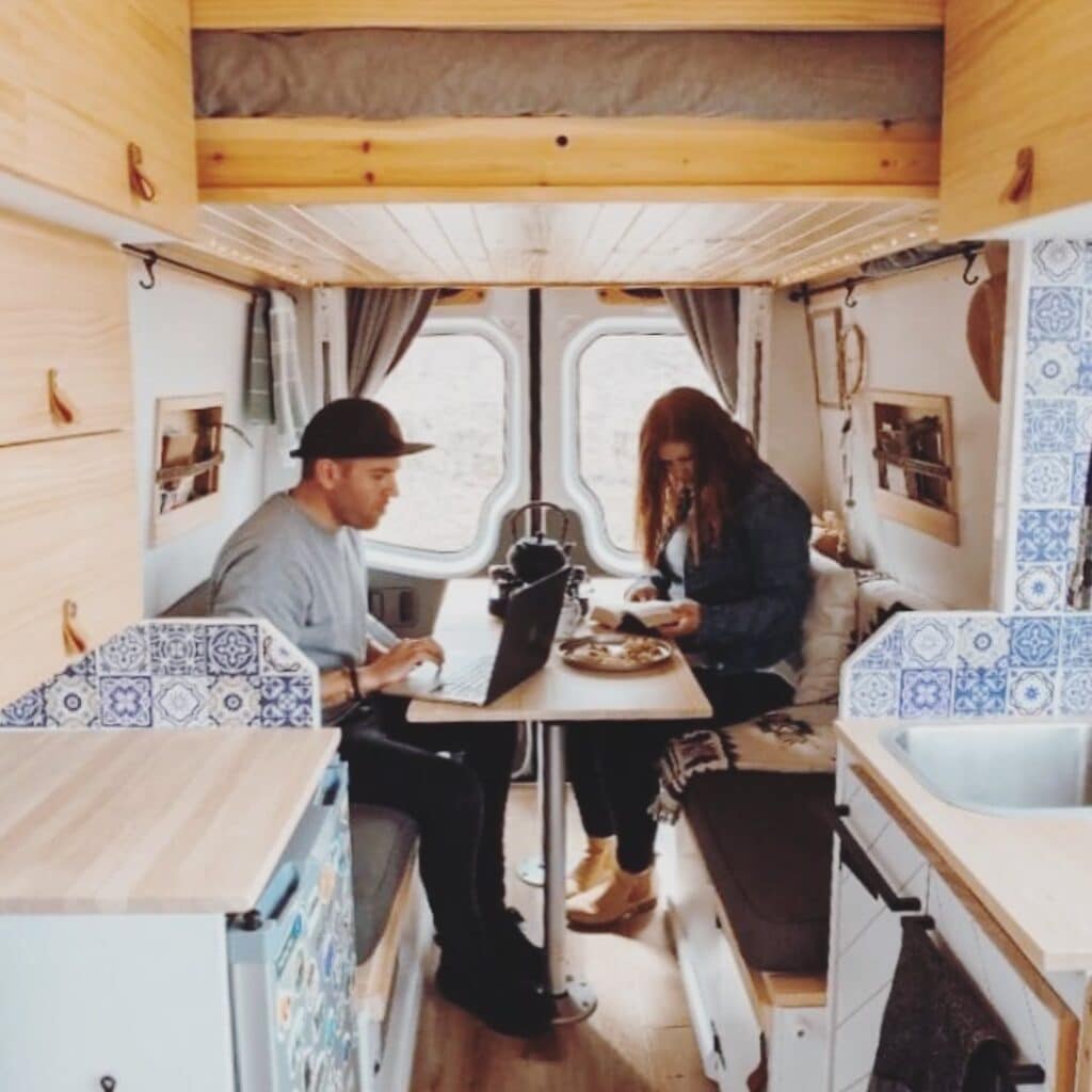 @benzson_the_van couple sitting inside a converted sprinter van, interior sprinter van conversion