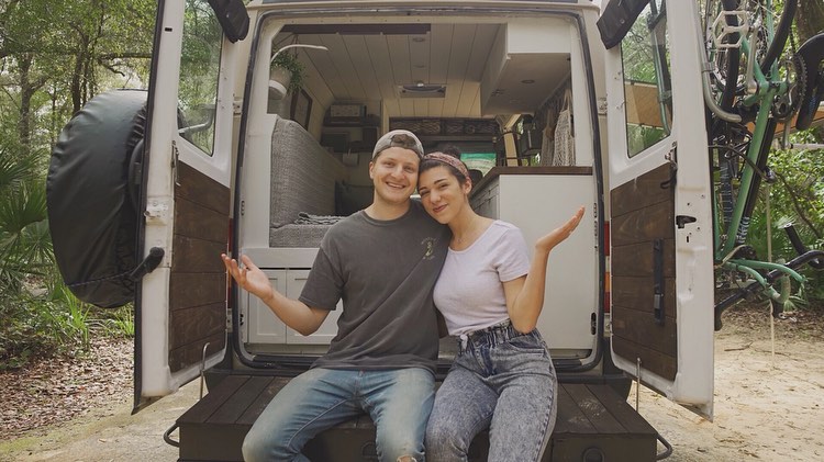 @louisthevan couple sitting at the back of their sprinter van home