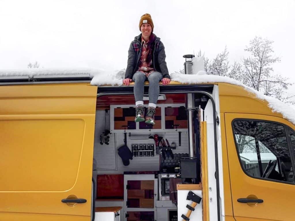 @sonnysideup.co Woman sitting on the roof of her sprinter van camper