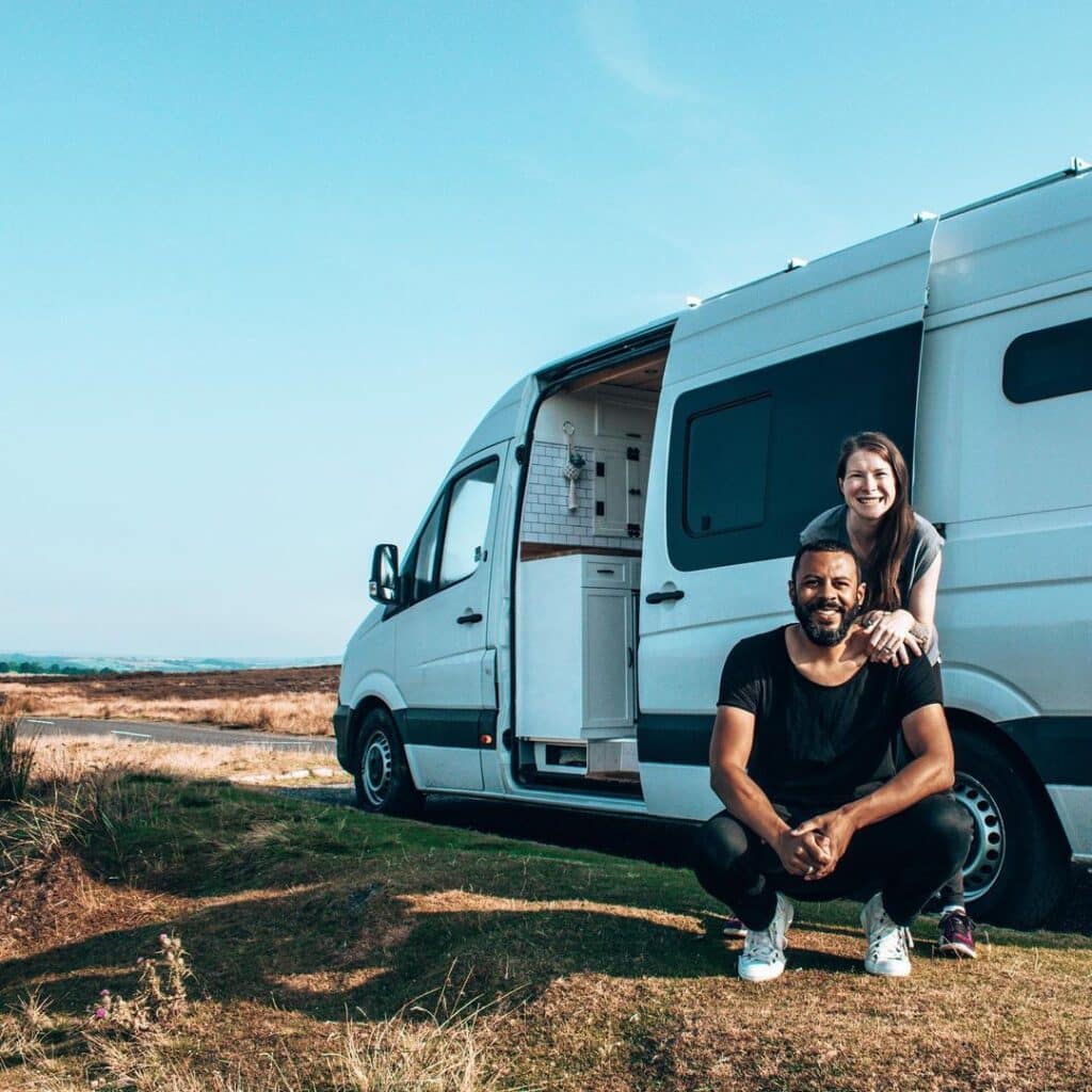 @thewholeworldornothing couple with their converted sprinter van parked on the side of the road